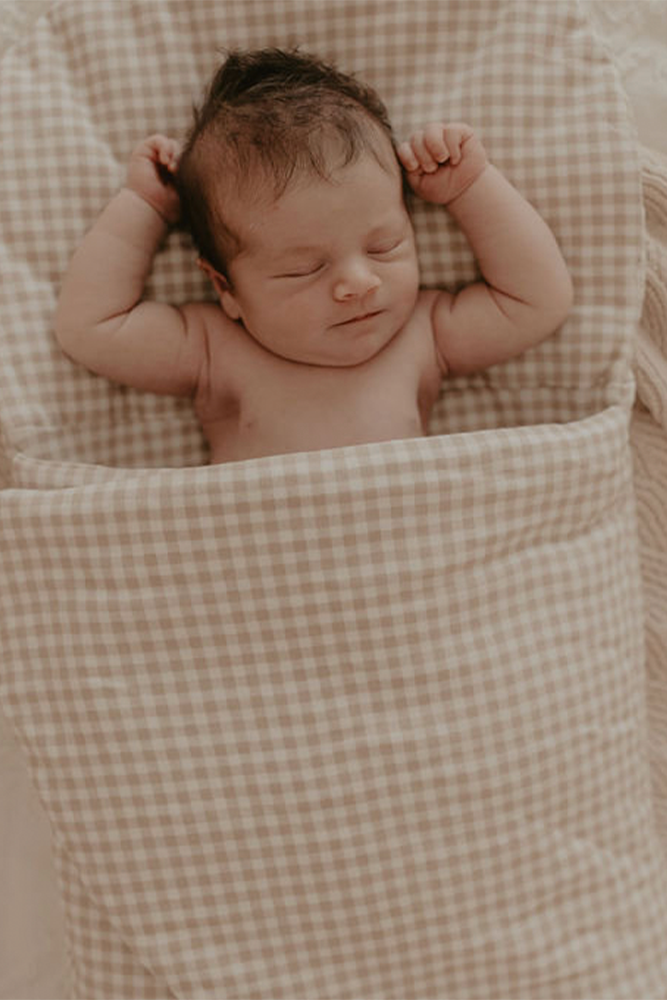 Baby sleeping in gingham Bundl wool wrap