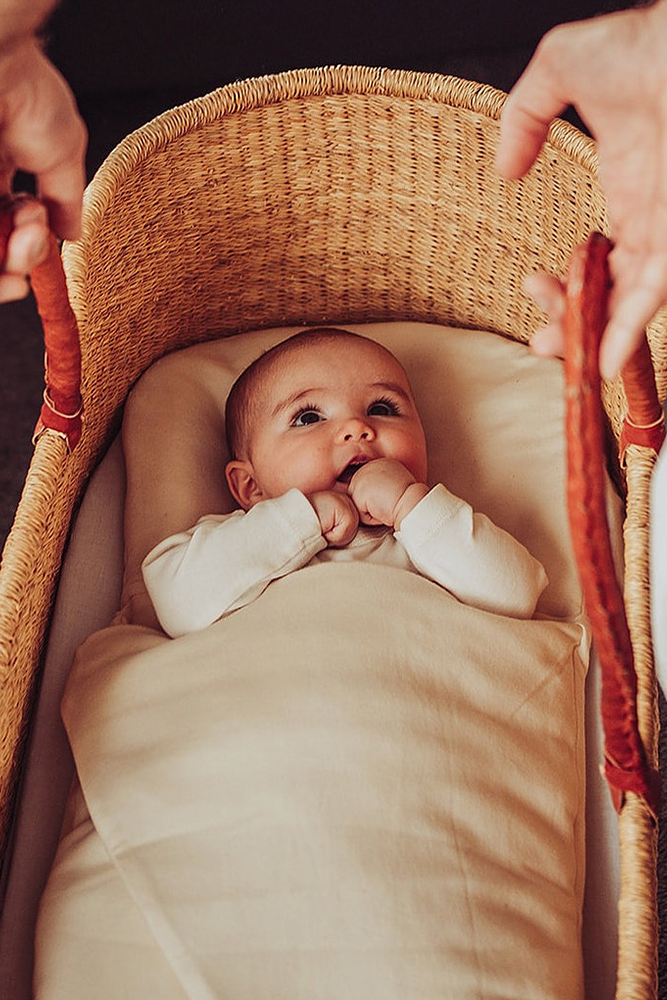 Baby awake in Bundl wool wrap in moses basket