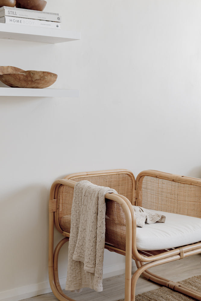 Beige blanket on rattan chair