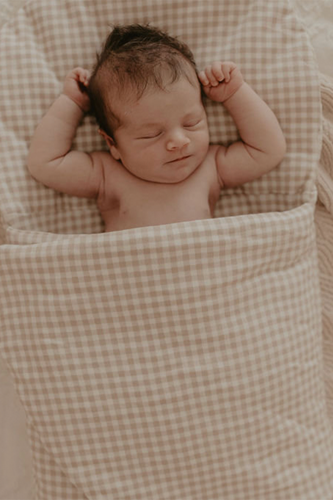 Baby sleeping in  gingham Bundl wool wrap 