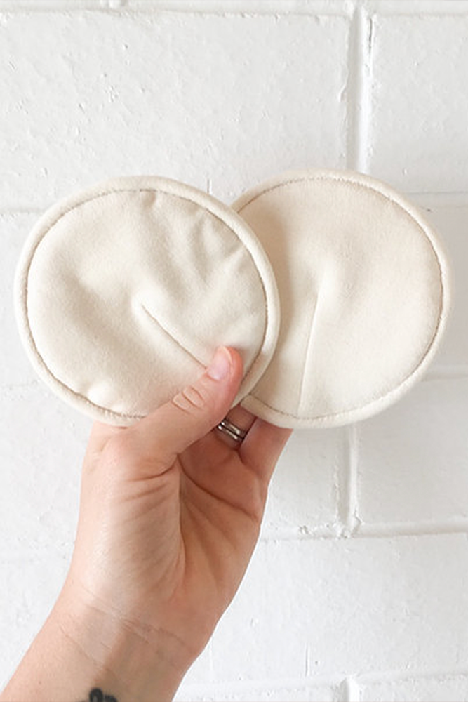 Reusable wool nursing pads in hands